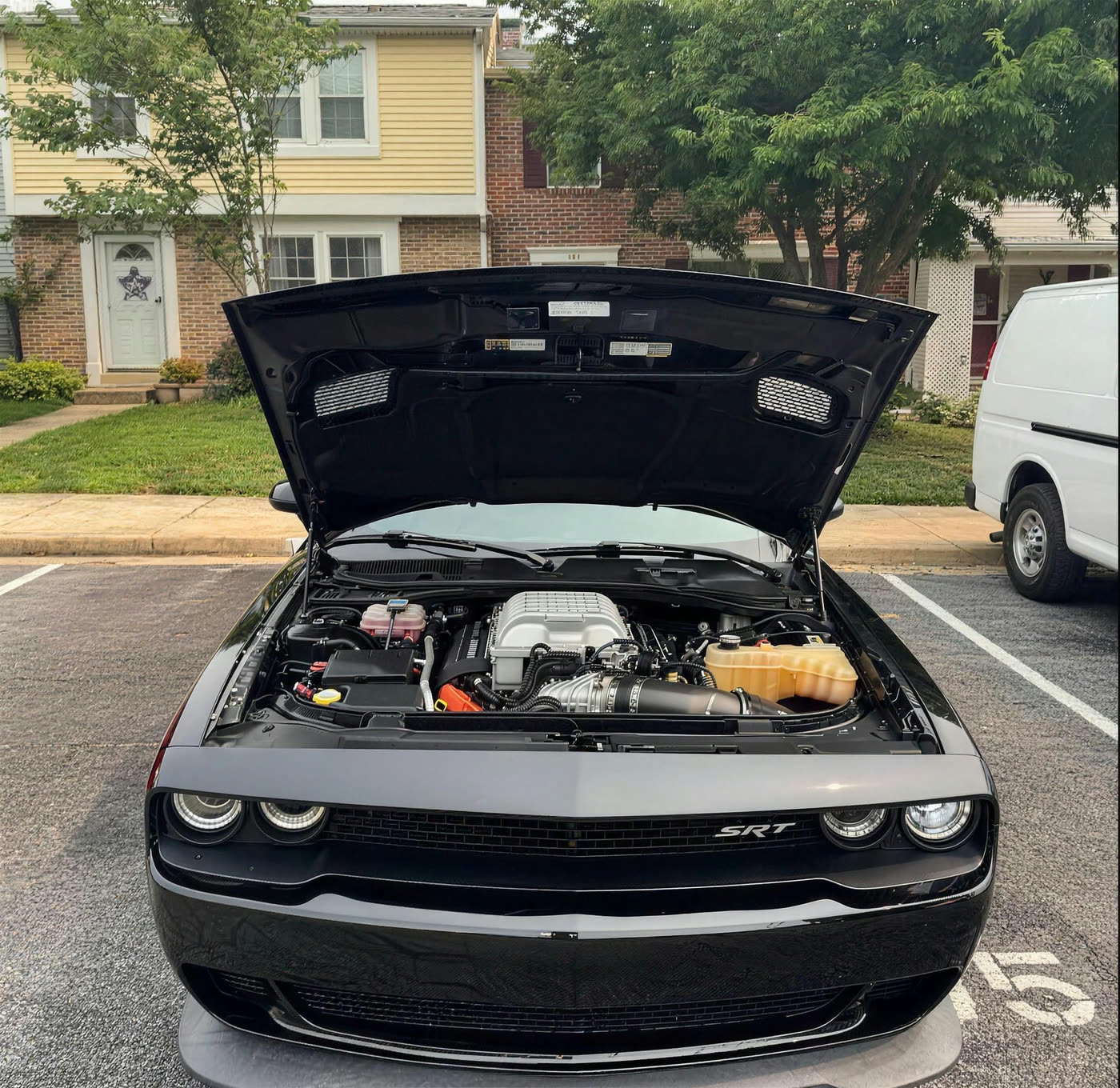 Dodge Challenger SRT Hellcat with the hood open showing a cleaned and dressed supercharged engine bay