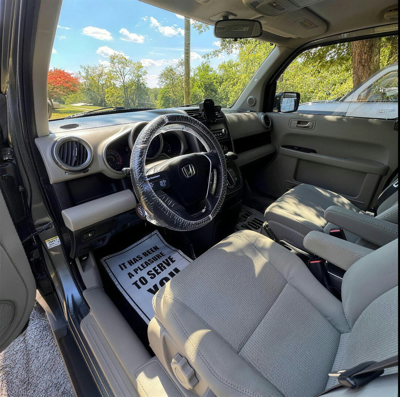 Honda Element interior with cleaned grey cloth seats and a branded steering wheel cover