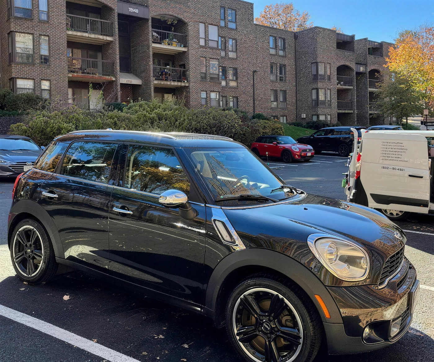 Black Mini Cooper Countryman detailed in an apartment parking lot with the Key City Details service van alongside
